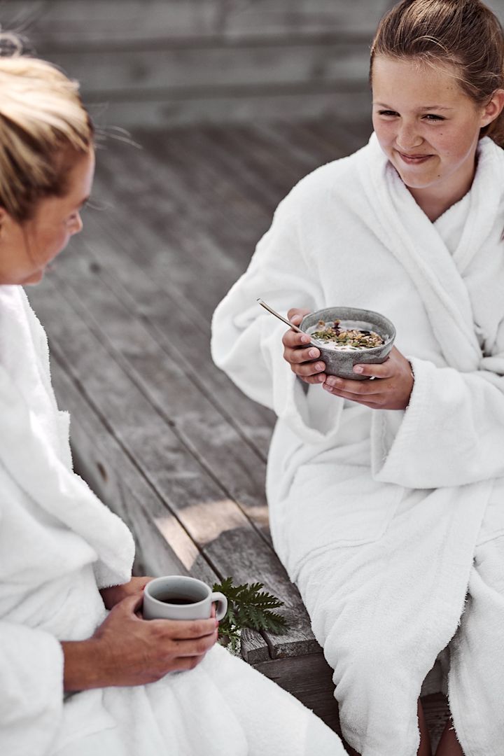 Mysig frukoststund på bryggan med smoothie bowl och kaffe i händerna. 