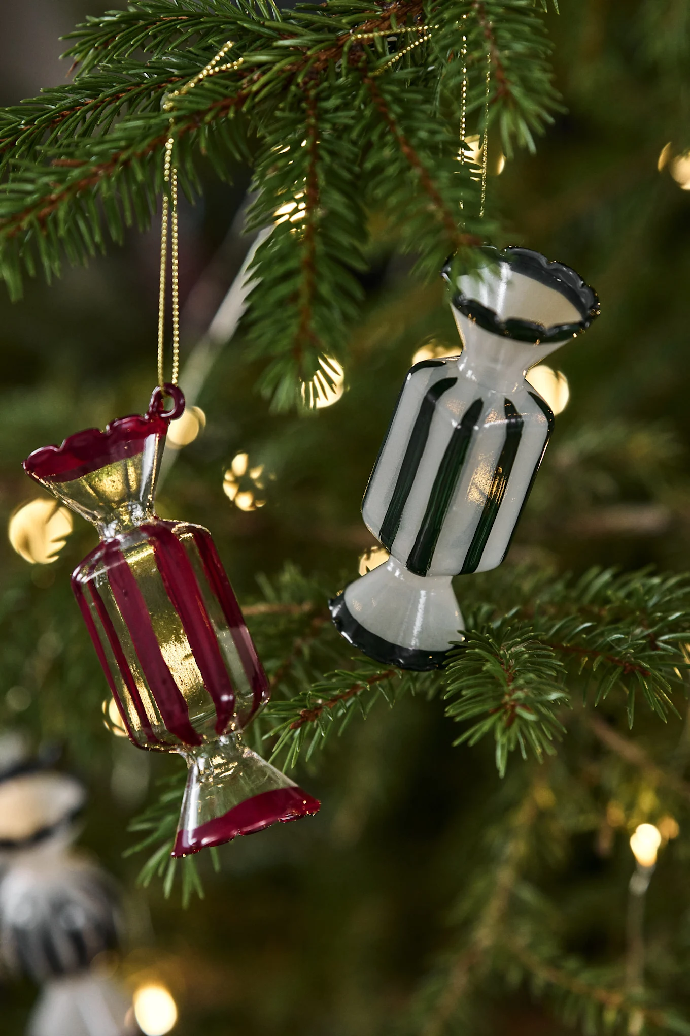 Candy-dekorationshängarna från Pluto Design ingår i juldekorationen 2025 och ligger här på ett bord.