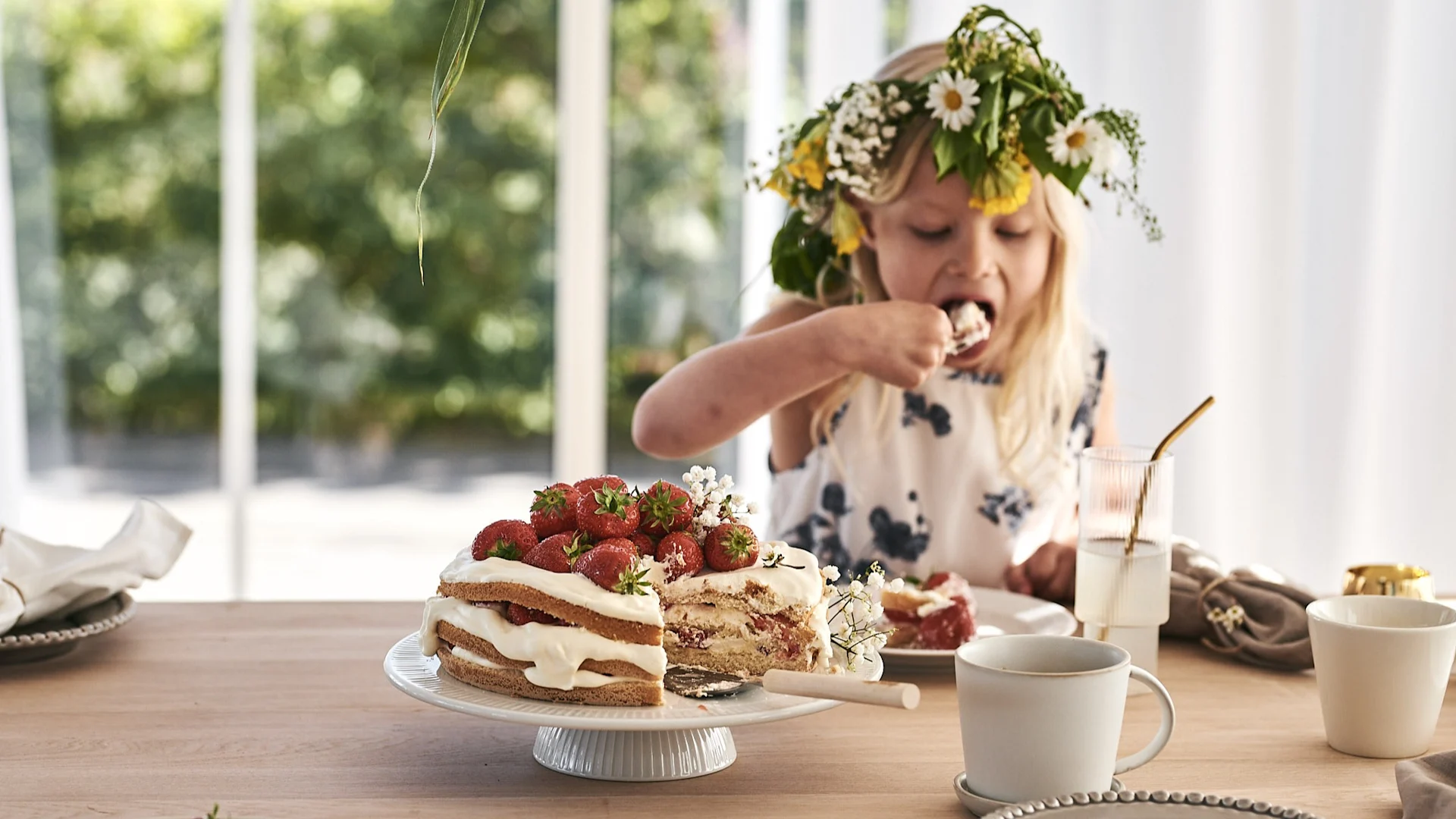 En jordgubbstårta på vitt tårtfat med ERNST tårtspade. 