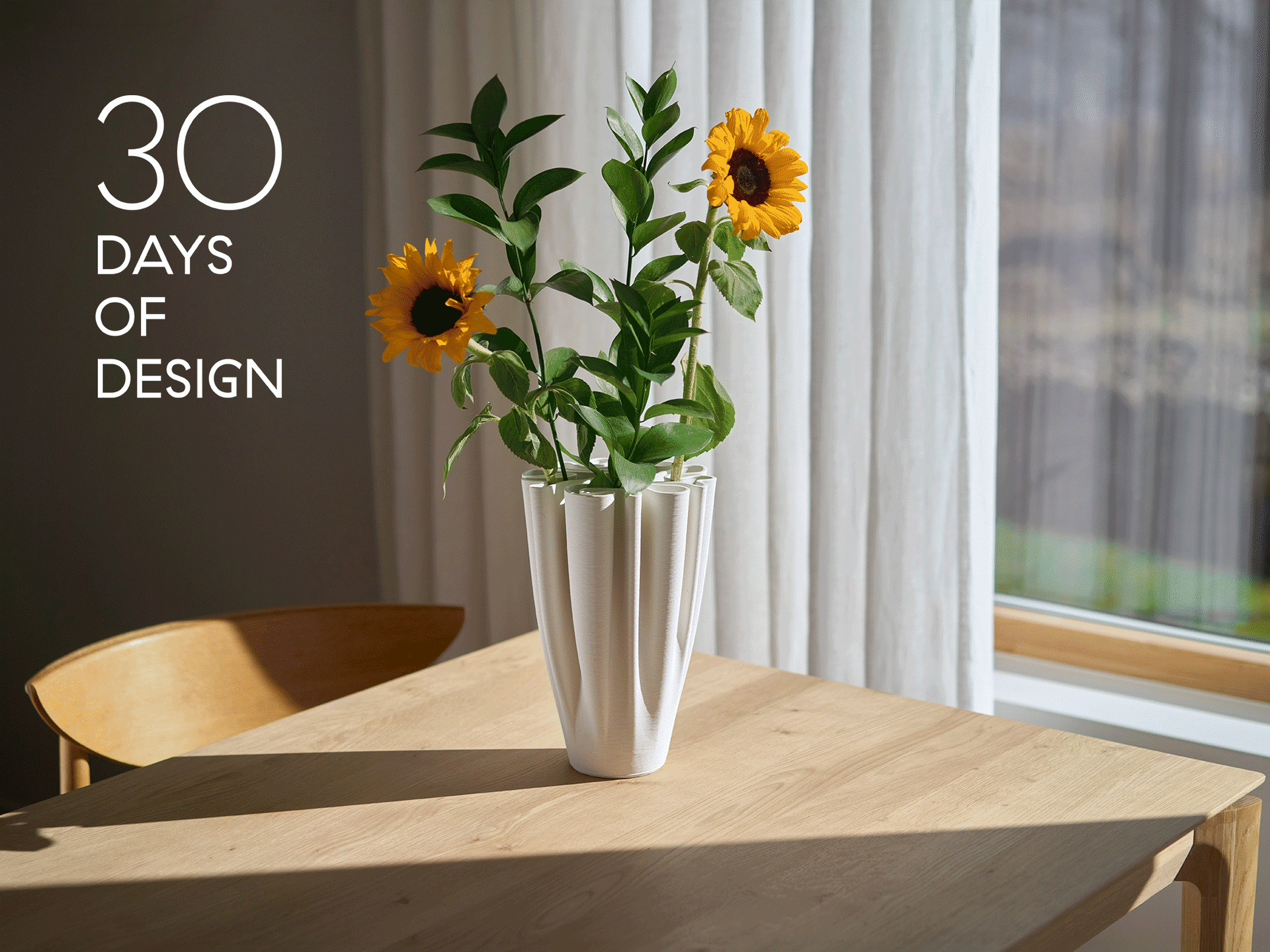 En vit veckad vas med solrosor på ett träbord framför ett fönster. Texten lyder: 30 DAGAR AV DESIGN.