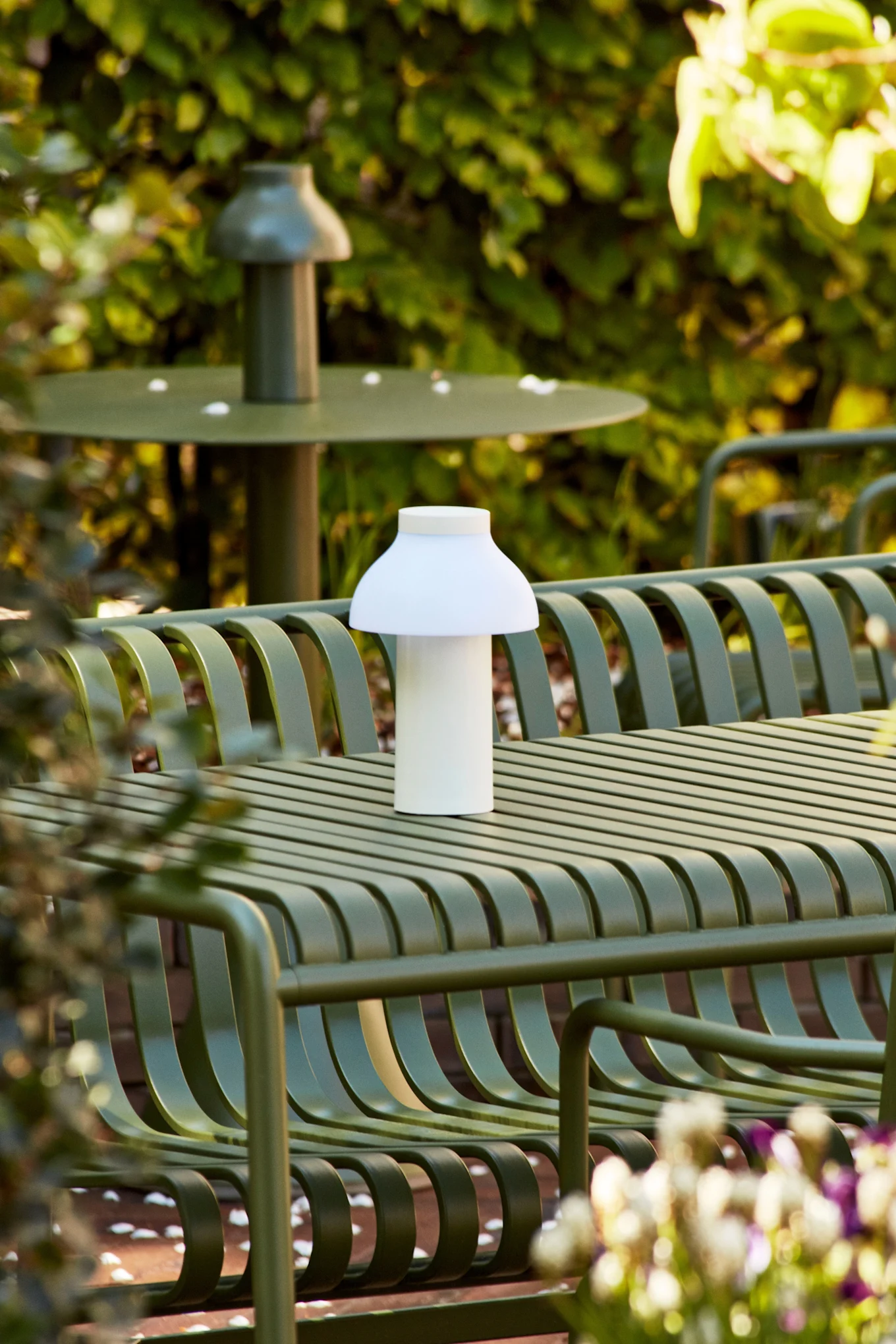 PC potable vit bordslampa är en uppladdningsbar lampa som står utomhus på ett grönt bord. 