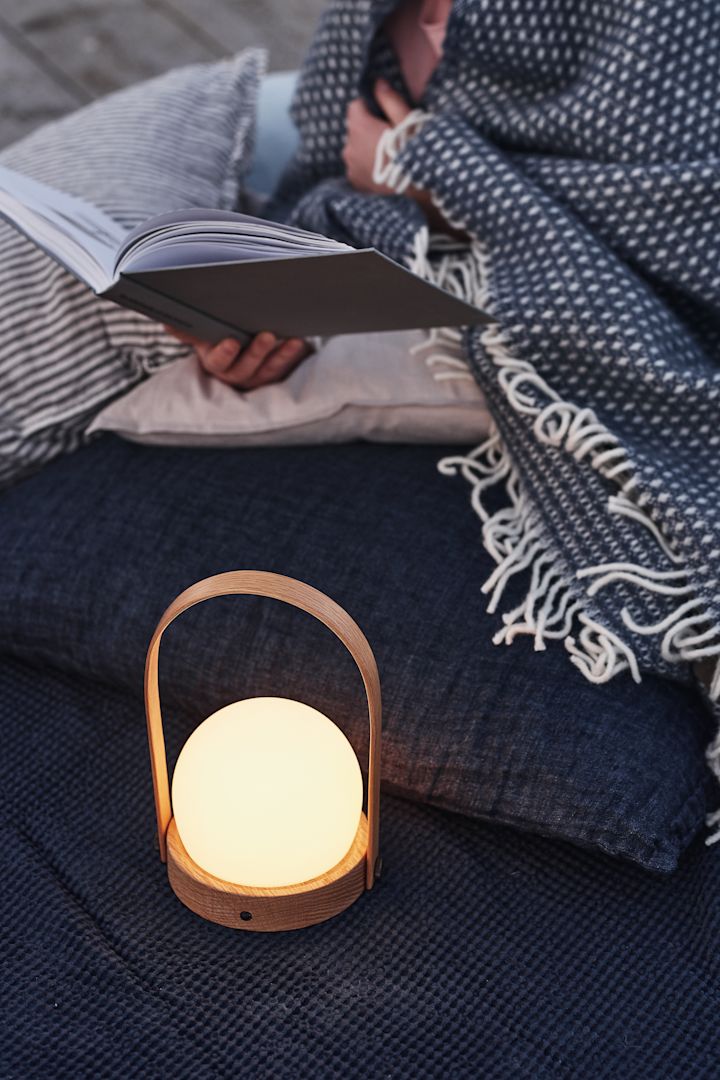 Skapa en mysig uteplats genom att inreda din uteplats med ombonad belysning såsom Carrie portabla bordslampa som du kan ta med dig överallt.