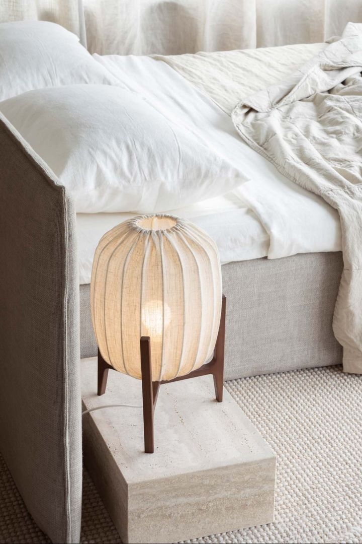Prisma bordslampa från Watt & Veke är en liten bordslampa med tre ben i trä och en transparent tygskärm i vitt. En stämningsfull och dekorativ sovrumslampa som är lika fin att ställa på nattduksbordet som i fönstret.