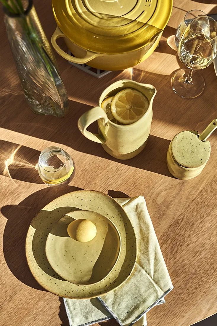 En gul påskdukning med rustikt, gulspräckligt porslin från Ferm Living.