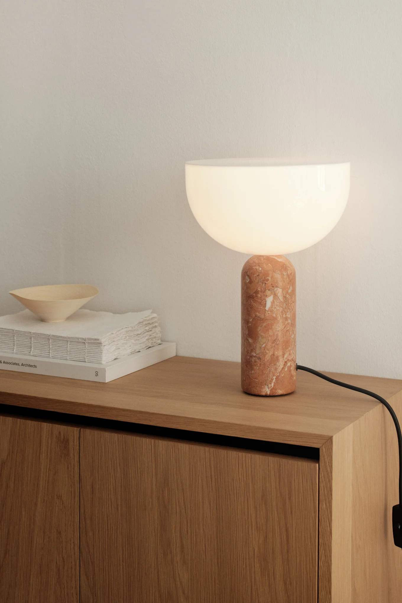 Lägg ihop dina idéer för belysning i matsalen. Här ser du bordslampan Picasso i beige från Belid stå på ett sidobord. 