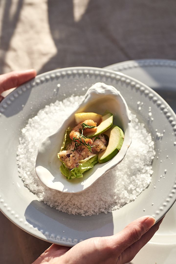 Skapa semesterkänslan i ditt hem med medelhavsinredning såsom Oyster serveringsskål i vitt från By On format som ett ostronskal.