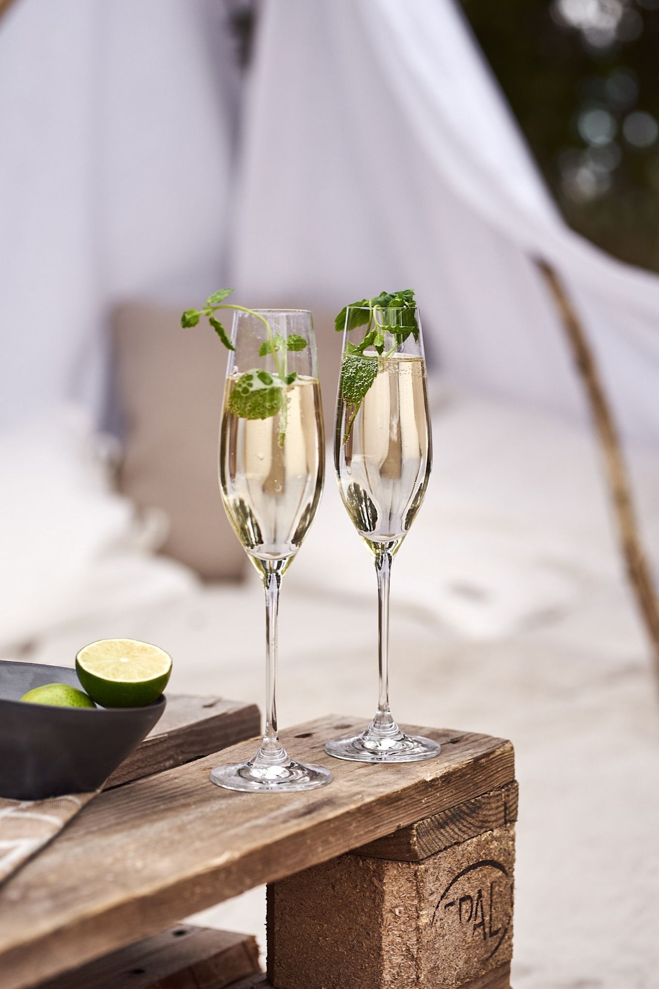 Champagneglas från Scandi Living står på lastpallen på en glamping-utflykt. 