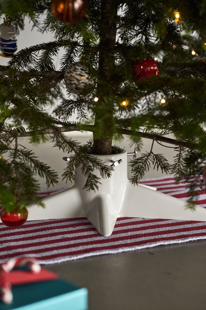 Dekorera julgranen med årets julgranspynt 2021 i 4 olika stilar enligt Nest Trends - Nurture, Share, Boost och Cultivate. Här ser du en randig matta från HAY i rött och vitt samt vit julgransfot från Born in Sweden.