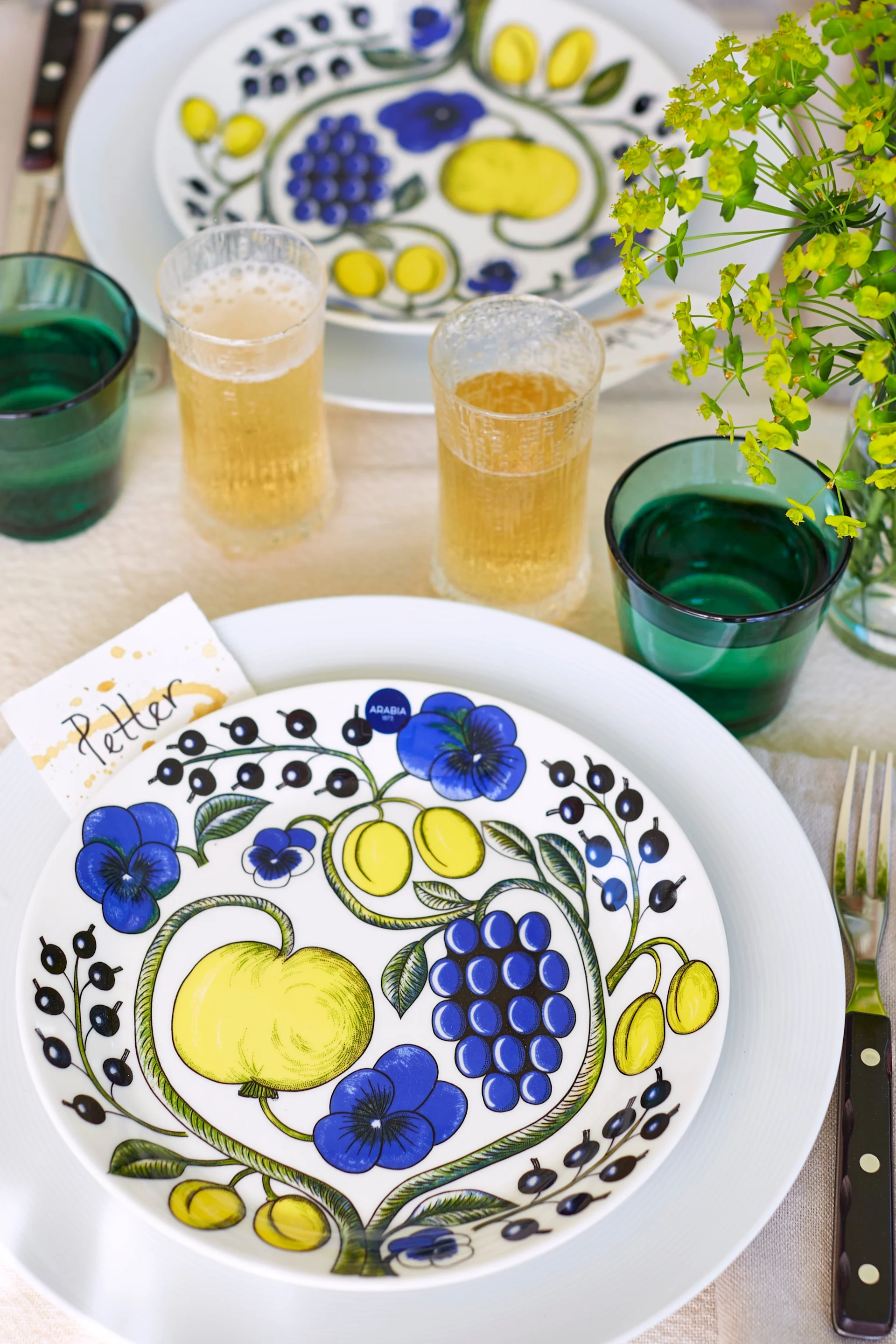 Duka till midsommar med mönstrat och färgglatt porslin från Aravia, grillbestick från Gense och gröna dricksglas från Iittala. 