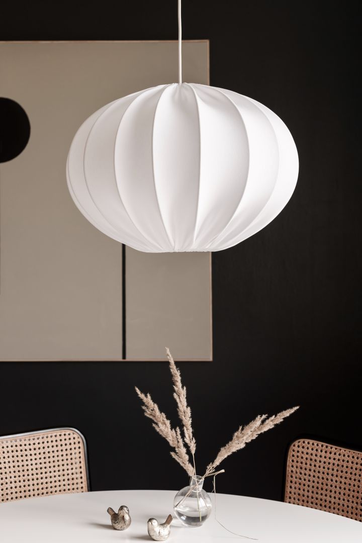 Förnya ditt hem med trendiga lampor - här ser du Boll taklampa från Watt & Veke i vitt vid ovanför matbordet.