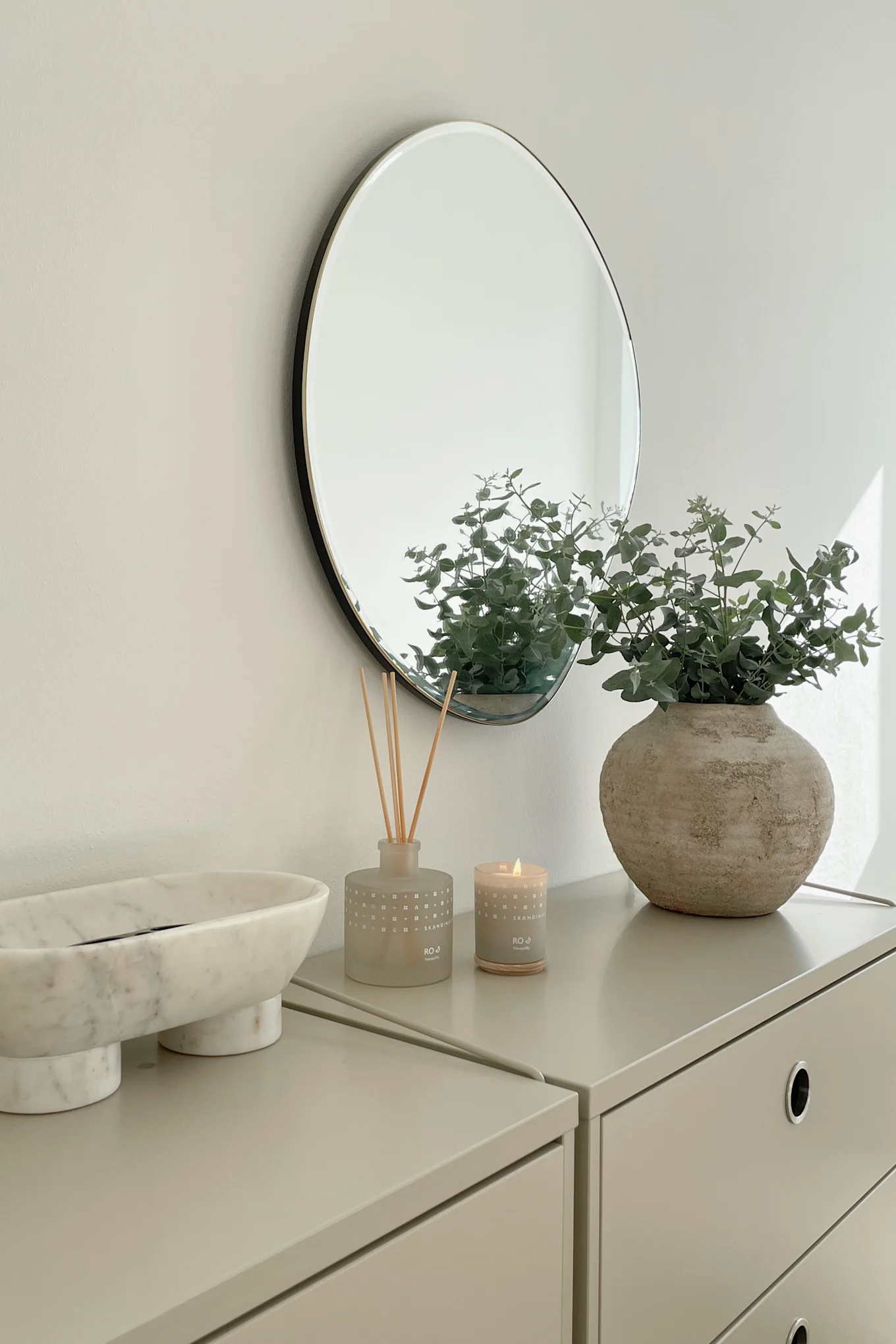 Inreda liten hall - inspiration hos @our_home_living med doftljus från Skandinavisk och färska blommor i en fin vas för att göra hallen mer inbjudande.
