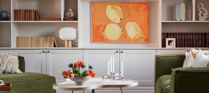 Inredningstrender 2024 - vardagsrum med grön soffa, Swedese bord, poster med målat uttryck och stilren bokhylla. 