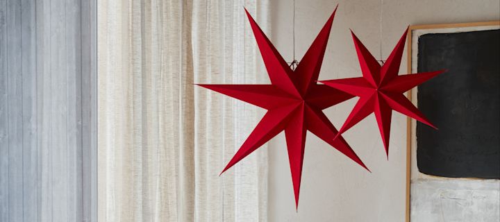 Här ser du en nykomling bland julstjärnorna, de röd- och vitmönstrade stjärnorna från Bare-kollektionen från Scandi Living, hängande på en dörr.