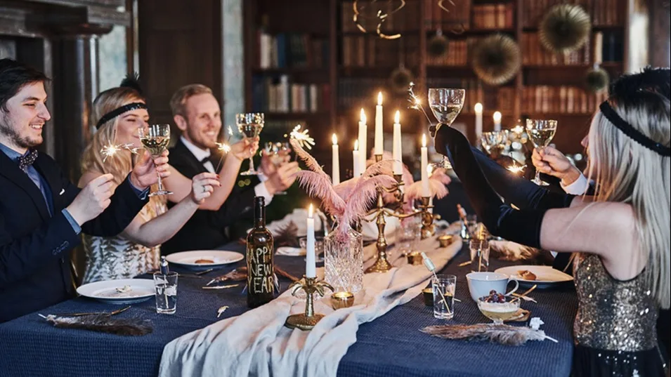 Sällskapet skålar på denna nyårsfest med Gatsby-tema i guld, blått och rosa.