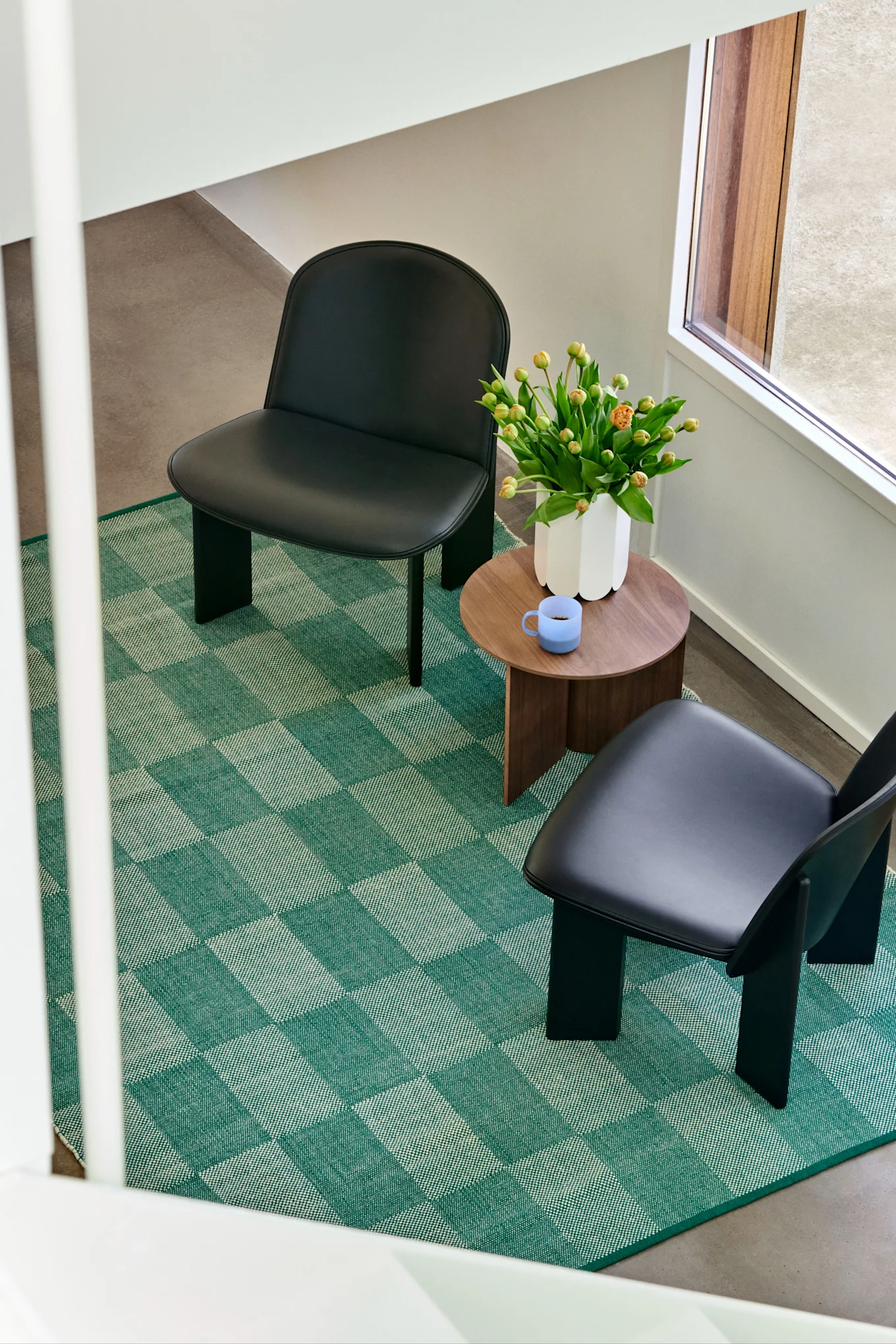 I vårens inredningstrender 2024 ser vi mycket mönster, gärna rutigt och randigt i stort och smått. Här ser vi en grön-rutig matta från HAY ta plats i vardagsrumsmiljö, en inredningsdetalj som sticker ut och skapar blickfång i rummet.