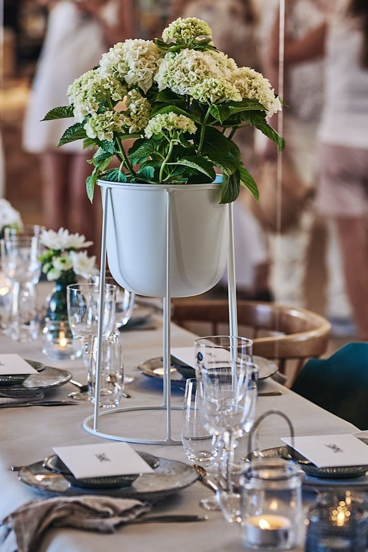 Duka till studentmottagning med iögonfallande centerpiece i form av en blompiedestal med hortensia i. 