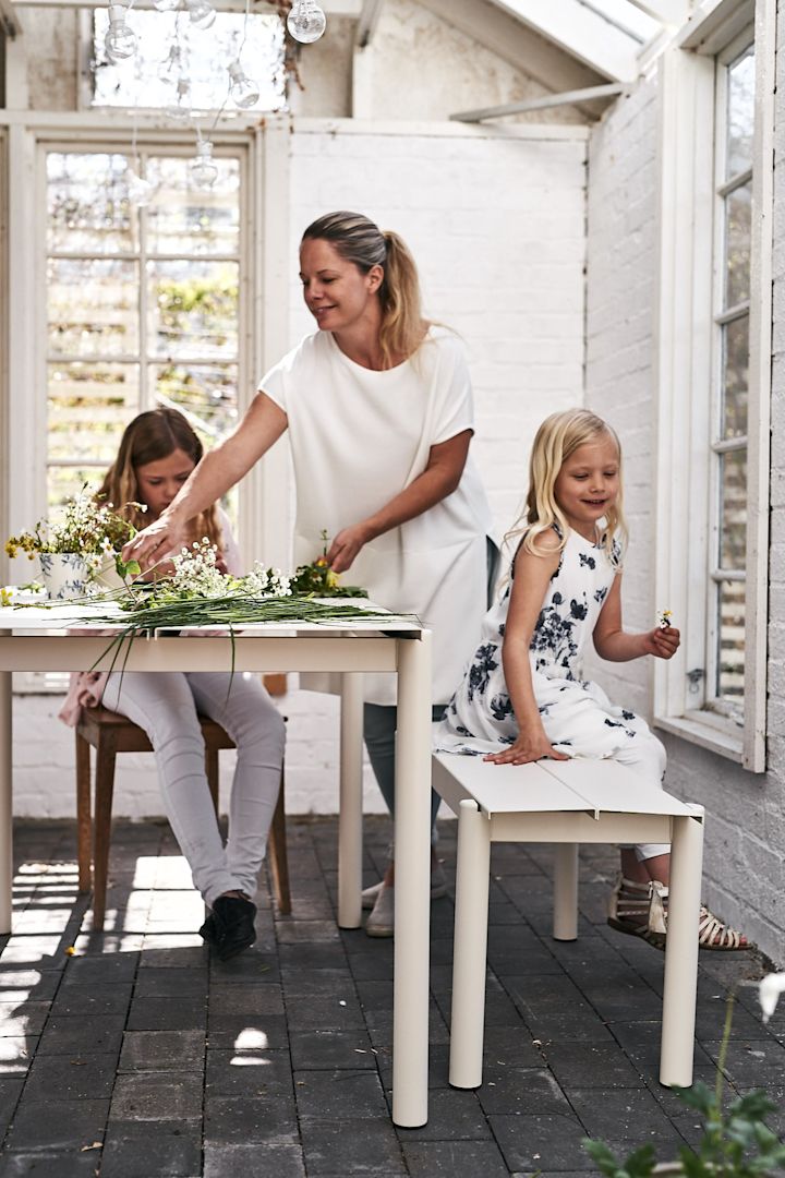 Familjen binder midsommarkrans i växthuset och Linear stålbord från Muuto passar perfekt för ändamålet. 