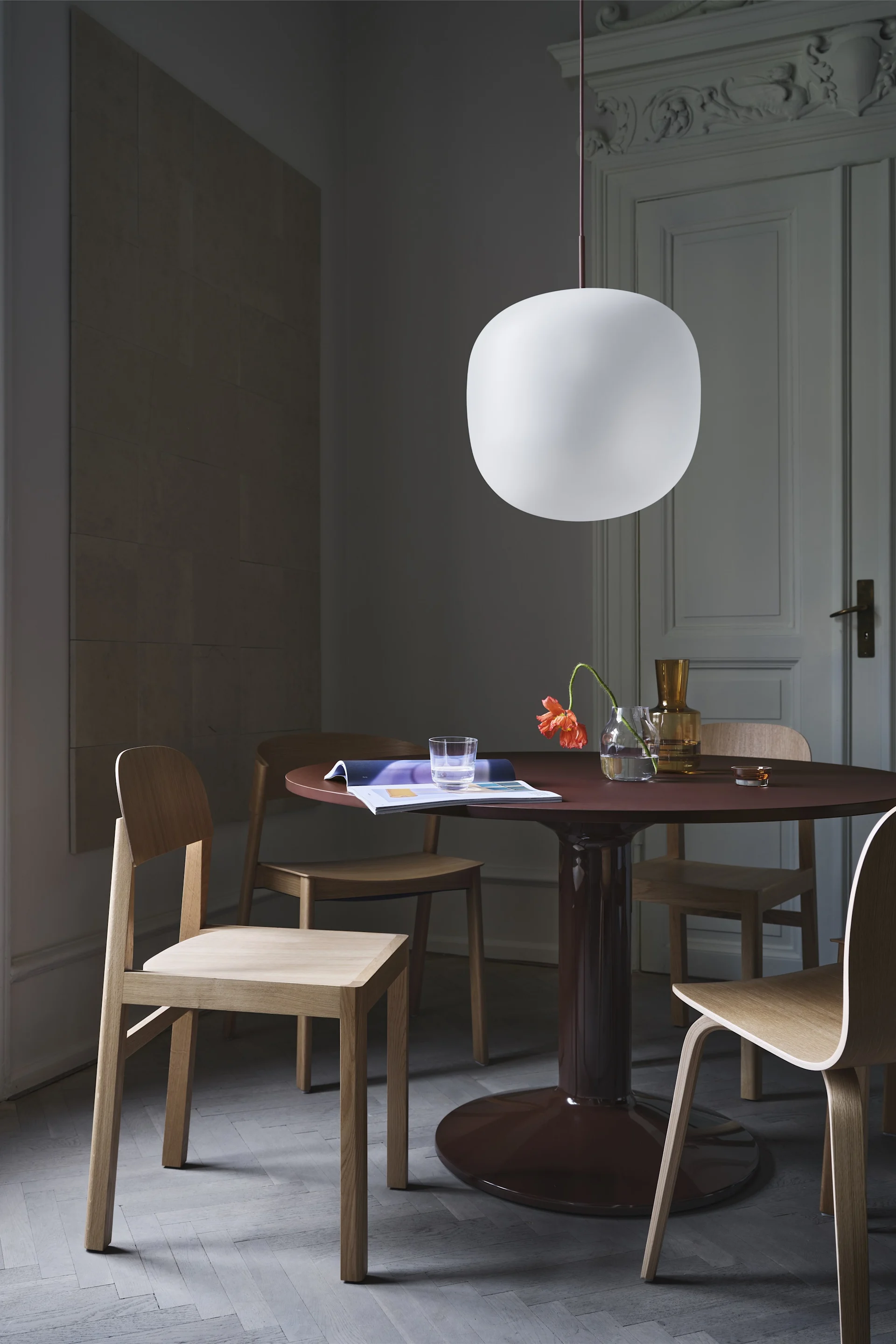 Cover chair är en av Thomas Bentzens mest berömda möbler, här i solid ek vid mörkrött, runt matbord.