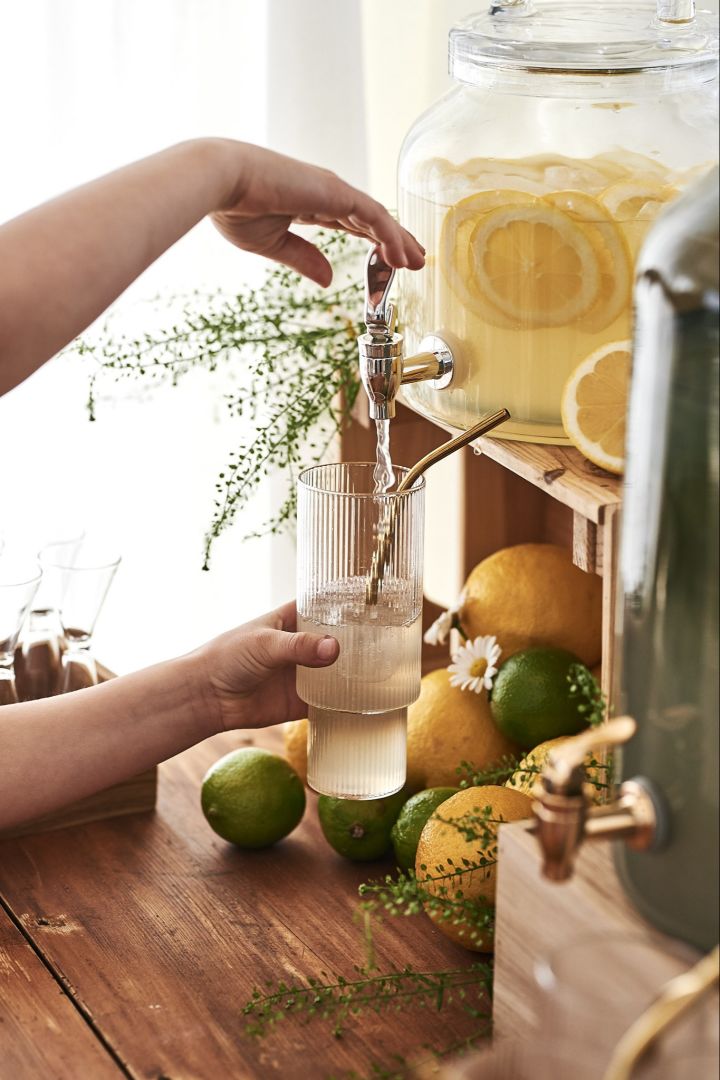 Ett svalkande glas lemonad hälls upp i Ripple long drink-glas från Ferm Living på det ljuva midsommarfirandet. 