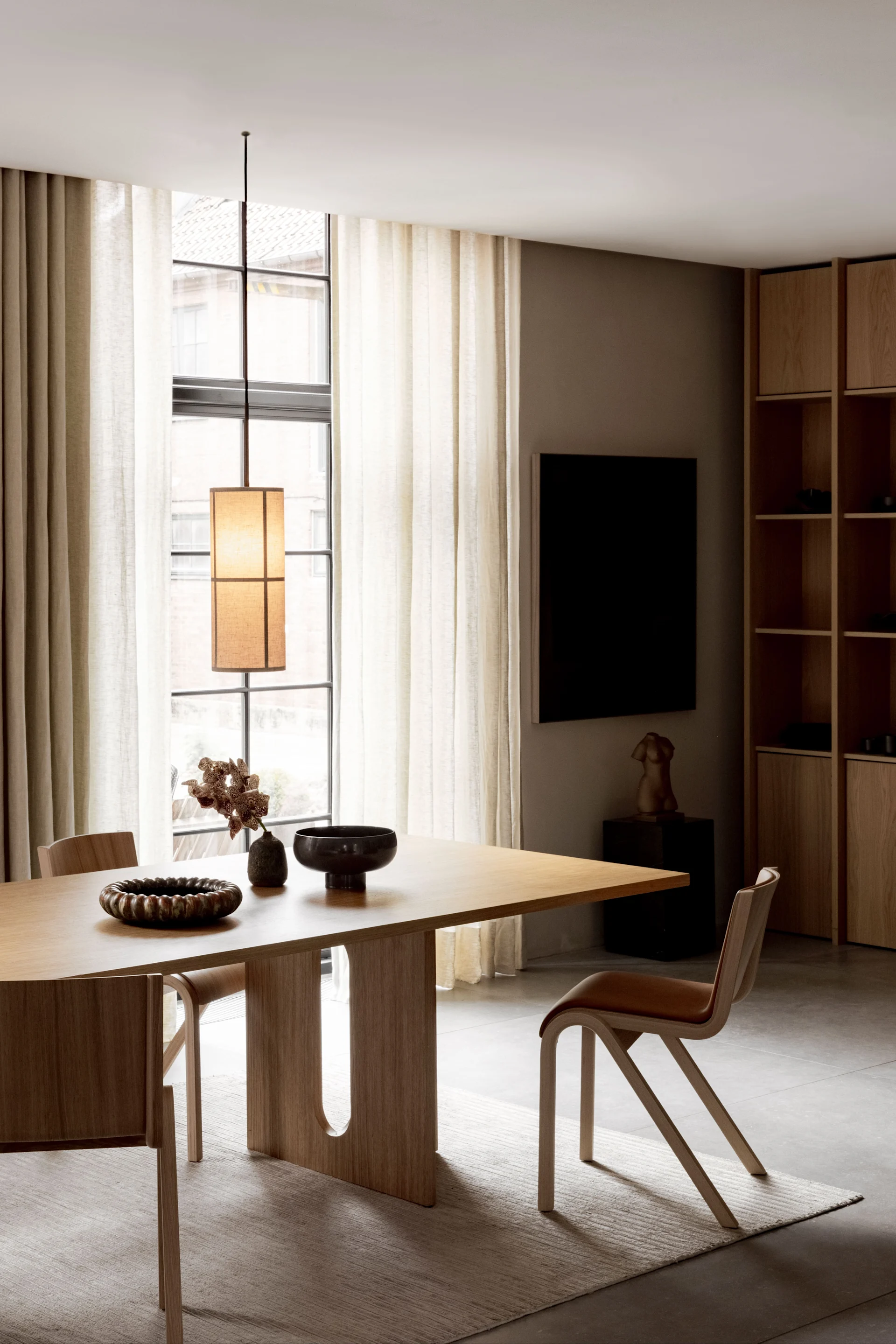 En matplats med möbler från Audo Copenhagen lyses upp av Hashira pendant lamp.