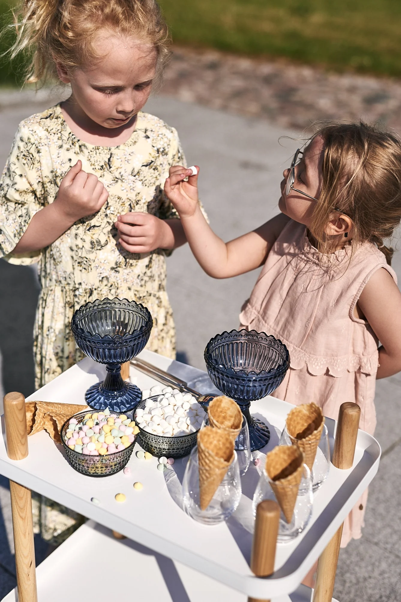 Familjens minsta tar för sig av glassbuffén som serveras på ett brickbord från Normann Copenhagen.