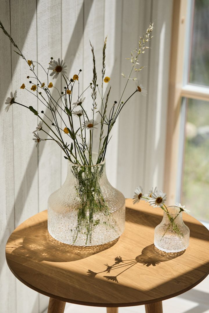 Den bästa vasen för små buketter och enskilda blommor är en liten eller en minivas som Ultima Thule-vaserna som du ser här i solskenet på ett bord. 