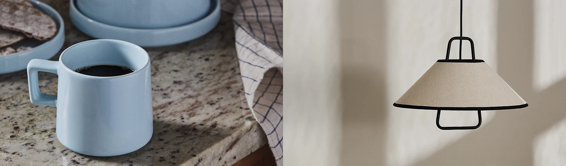 Ljusblå kaffemugg på granitbänkskiva och en beige konisk taklampa med svart ram.