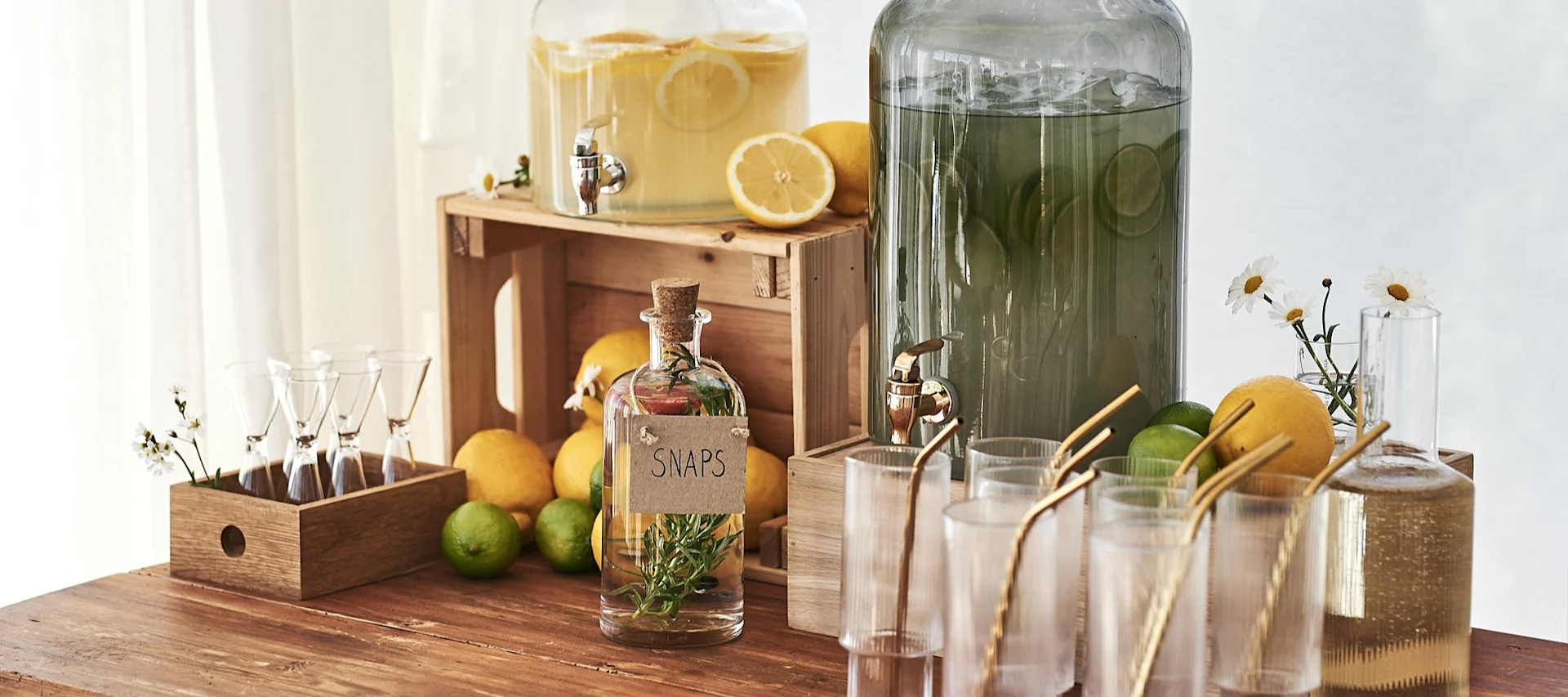 Drinkbord med stora glasbehållare från House Doctor på fyllda med lemonad, citron och lime är perfekt tips till sommarfesten.