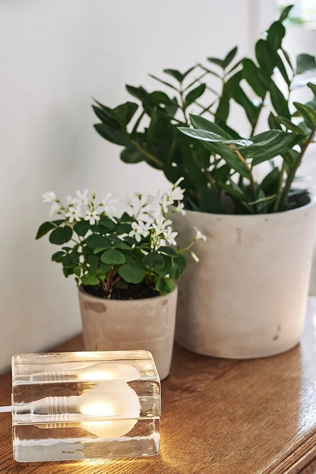 Block lampa från Design House Stockholm sprider stämning på ett sidobord bredvid ERNST krukor. 