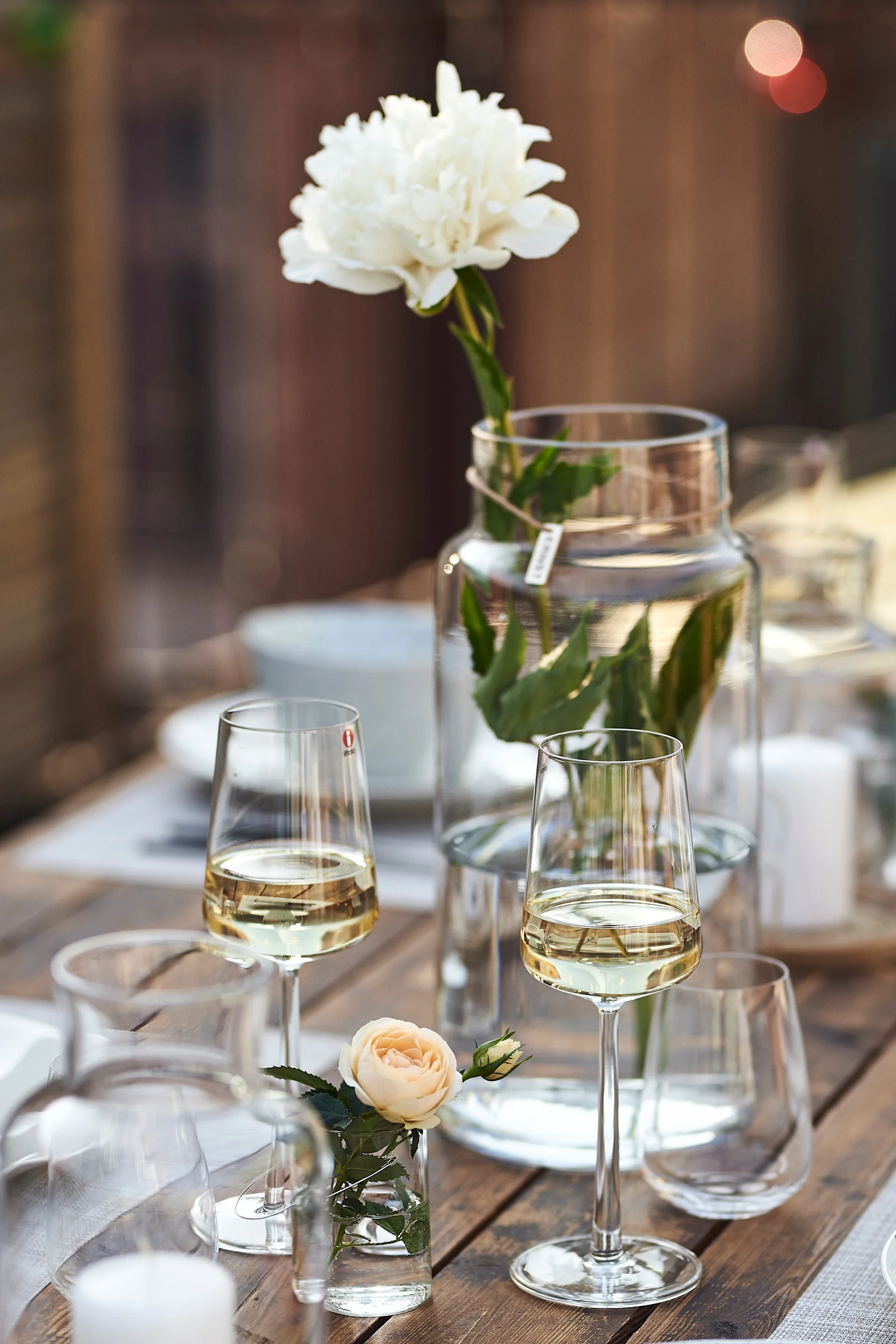 En modern festdukning med Essence vitvinsglas från Iittala vars skira design plockas upp av ljuslyktor och vaser i klarglas.