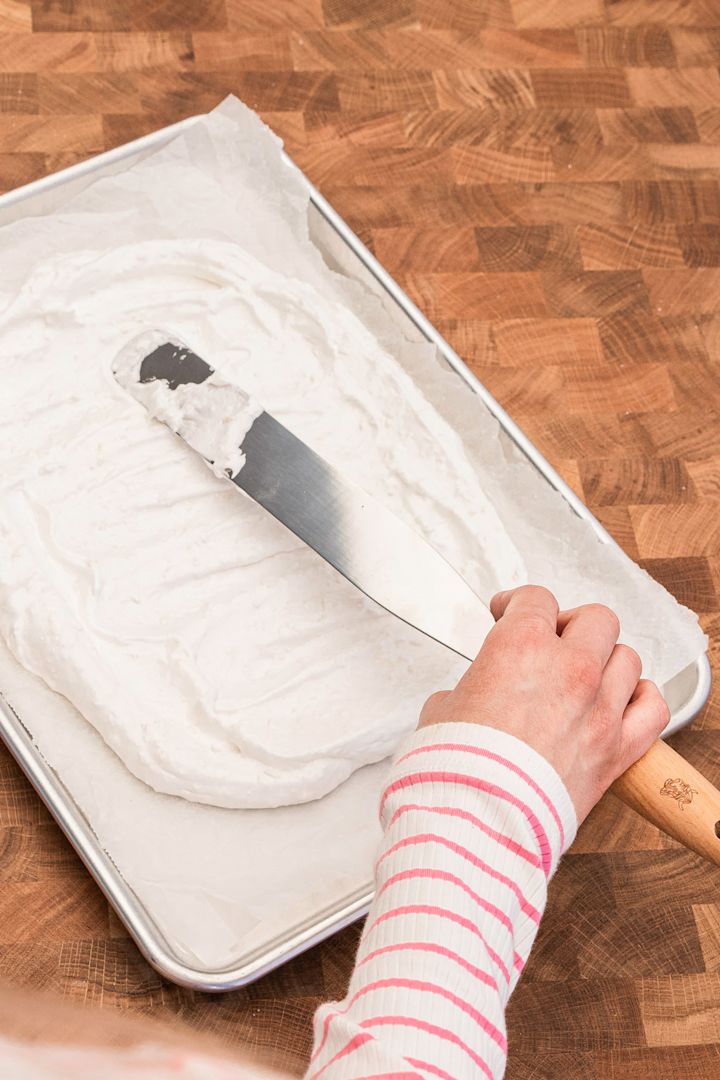 Baka en god marängtårta med hjälp av Baka med Fridas enkla påskrecept på en bakplåt från Nordic Ware. Bre ut marängsmeten med en tårtspatel som blir din botten.