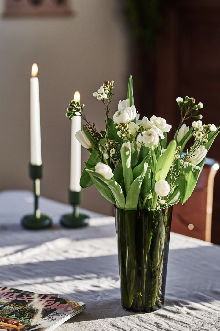Hög, grön Alvar Aalto vas från Iittala är god skandinavisk design som passar perfekt på matbordet. 