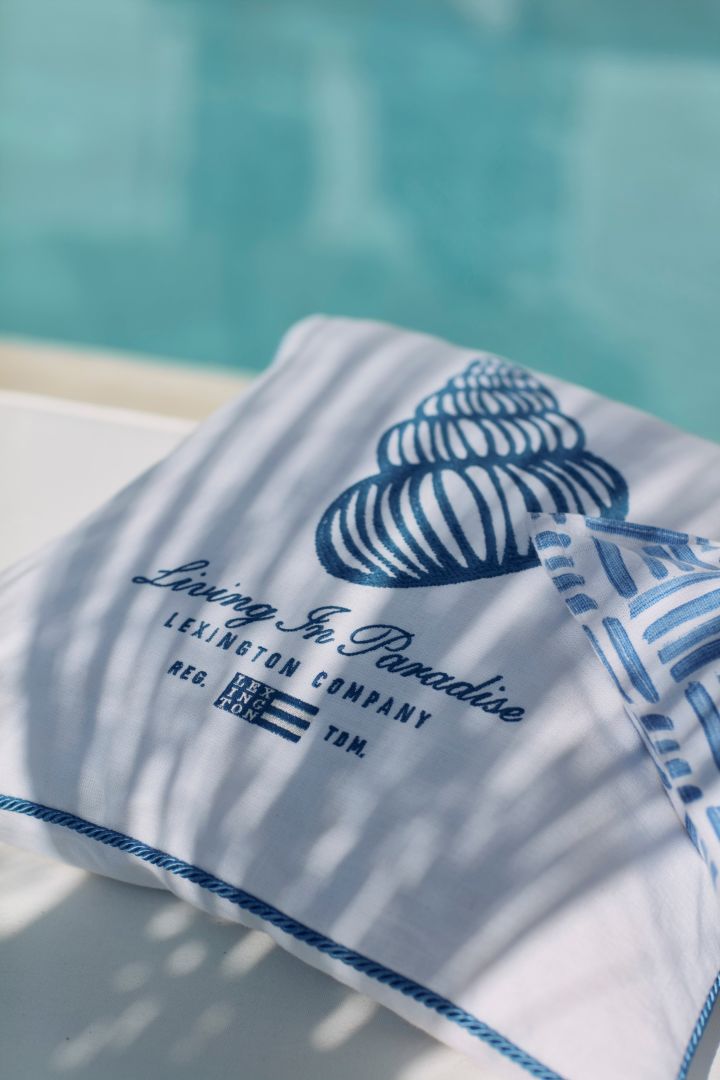 Skapa semesterkänslan i ditt hem med medelhavsinredning såsom Seashell Cotton Canvas kuddfodral från Lexington i blått och vitt med ett motiv i form av en snäcka.