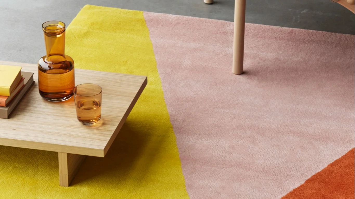 Ett mysigt vardagsrum med Circles ullmatta i beige och Circles ullpläd i grönt från NJRD som är designat av duon Carl Philip Bernadotte och Oscar Kylberg.