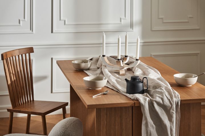 Stilren matplats med träbord från Design House Stockholm, Family stol, linneduk och porslin i form av skålar och tekanna i svart. 