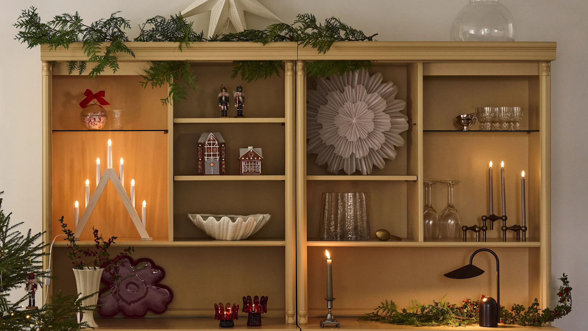 Juldekorerad bokhylla med julstjärnor och ljusstake som är perfekt för att komma i stämning till första advent. 