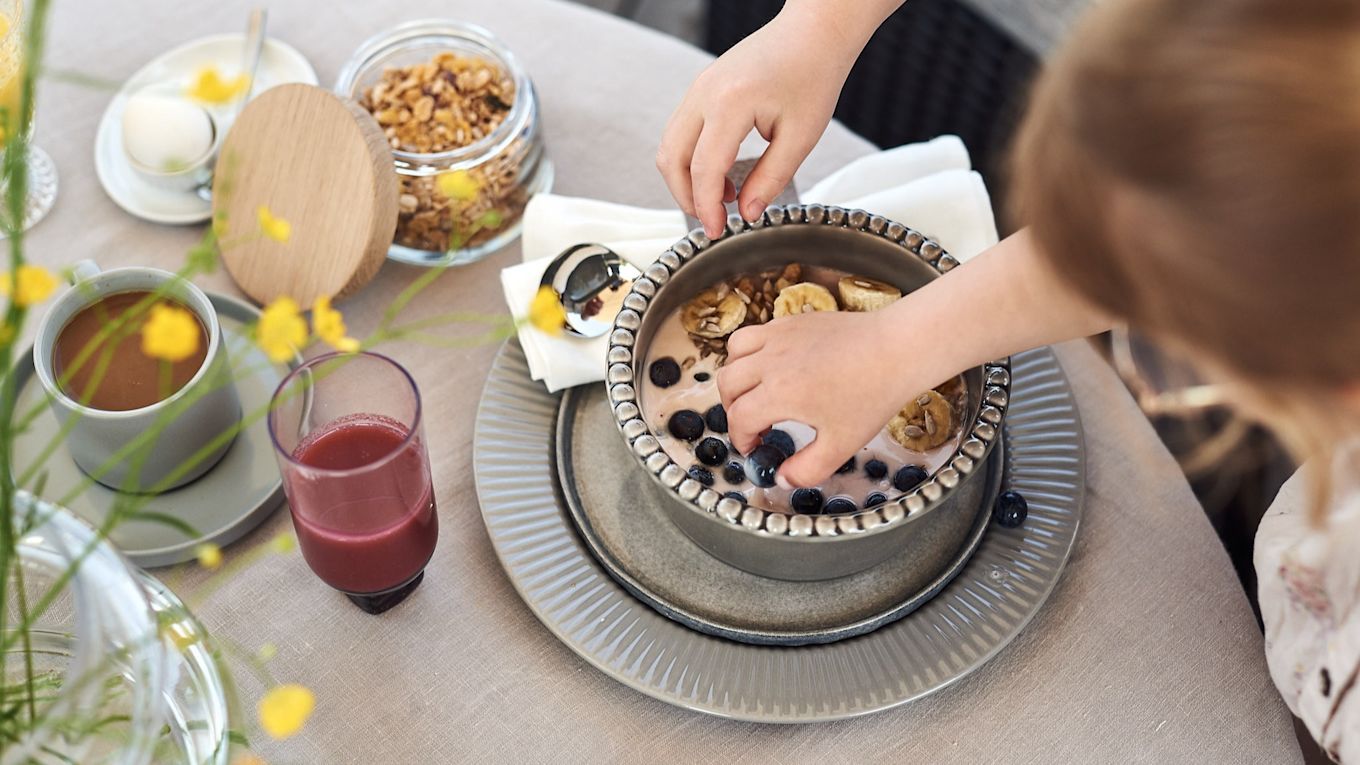 Små händer tar otåligt för sig av blåbären ur denna enkla smoothie bowl på yoghurt, banan och blåbär. 