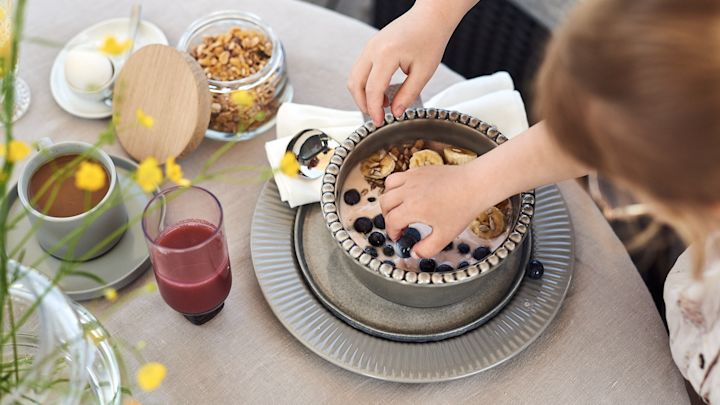 Små händer tar otåligt för sig av blåbären ur denna enkla smoothie bowl på yoghurt, banan och blåbär. 