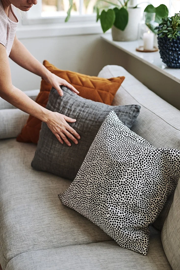 Soffan görs i ordning med kuddar från Marimekko, Himla och Northern i stilren design. 