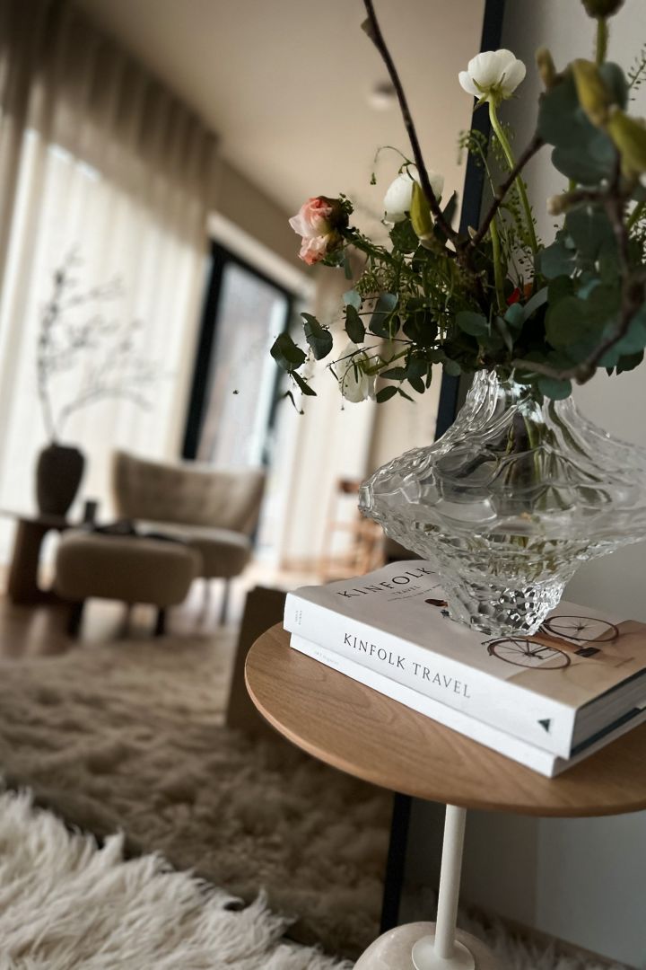 Norska influencern Helene Wold @villanyhus har dekorerat &Tradition sidobord i vitt och ljust trä med Skrufs vas med blommor i på en trave med böcker.