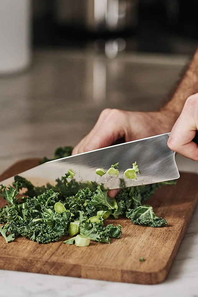 Middagen förbereds med att hacka grönkål på House Doctor skärbräda med kockkniv från Morakniv.