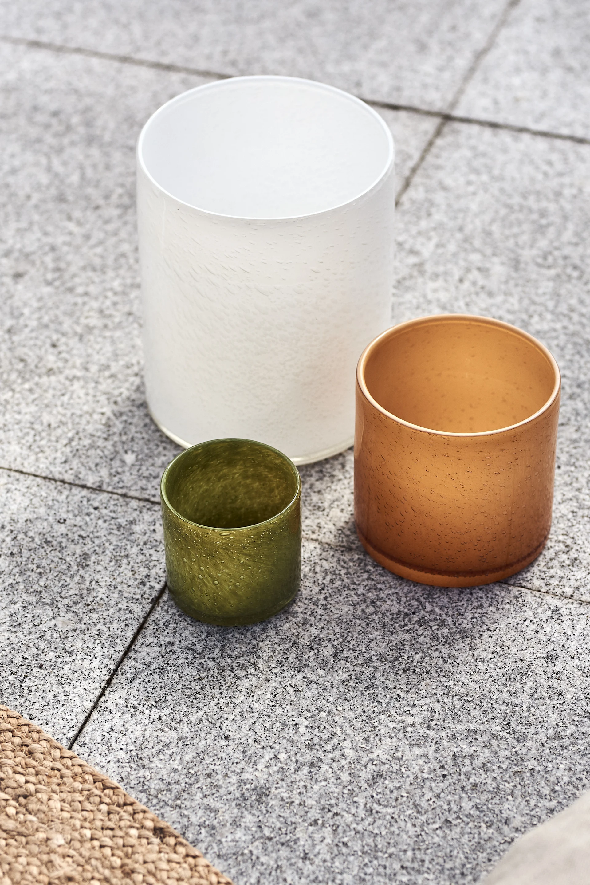 Calore ljuslyktor i vitt, orange och grönt från By On på uteplatsen. 