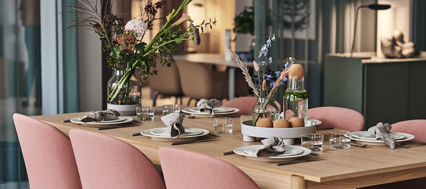 Muutos kontor i Köpenhamn är som ett välkomnande hem där ett uppdukat bord står med vitt porslin, glas och vaser från Muuto med vackra blommor i.
