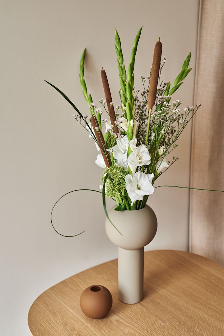 Trendiga och stilrena Pillar vas i färgen Shell från Cooee Design som har en rak fot och en klotformad topp är en av säsongens stora vaser för vårens blomster.