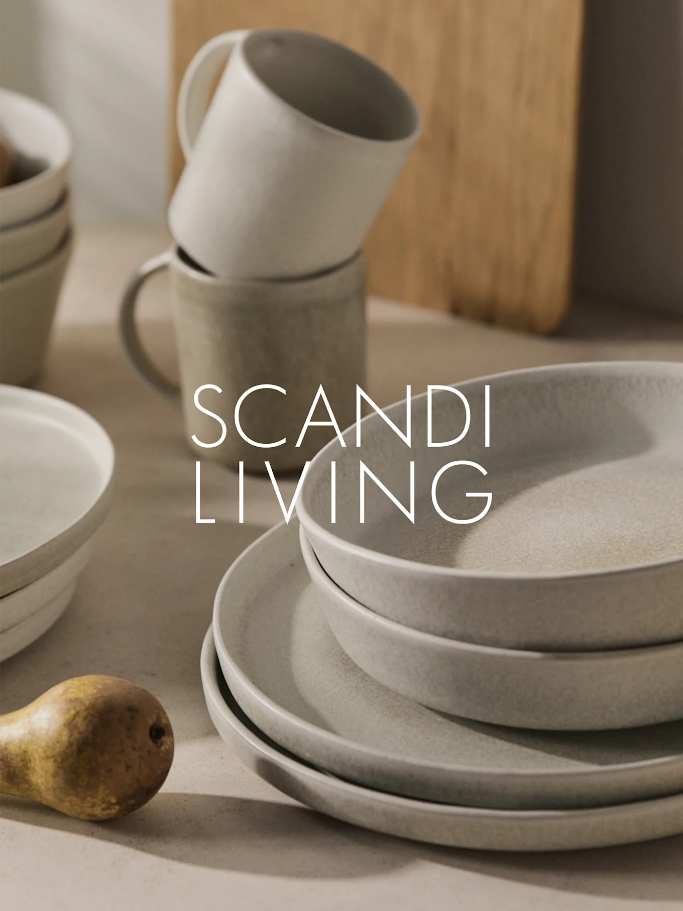 Staplat beige keramikporslin, muggar och ett päron med "SCANDI LIVING" text.