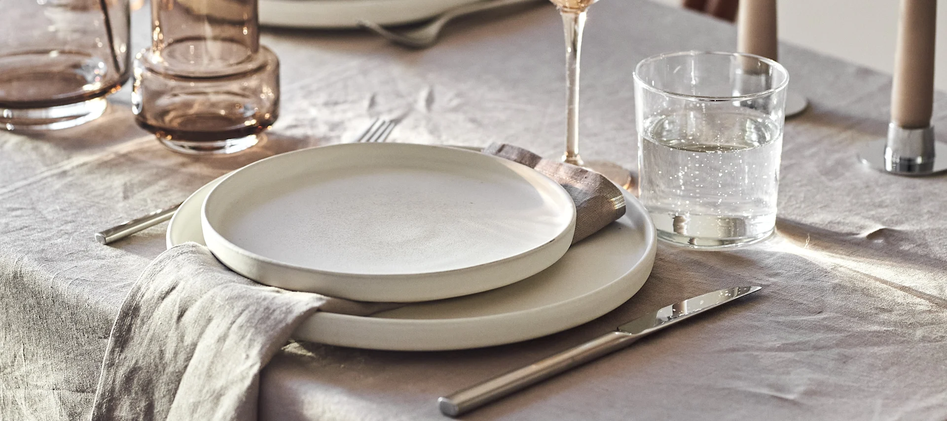Skapa vackra festdukningar genom fina Scandi Living bestick, elegant Sandsbro porslin från Scandi Living tillsammans med linneservetter i beige.