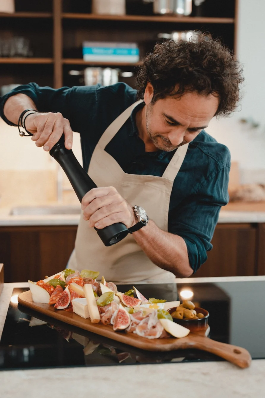 Mästerkocken Markus Aujalay i sitt kök med skärbräda och pepparkvarn från sitt eget varumärke av köks-och matlagningsprodukter. 