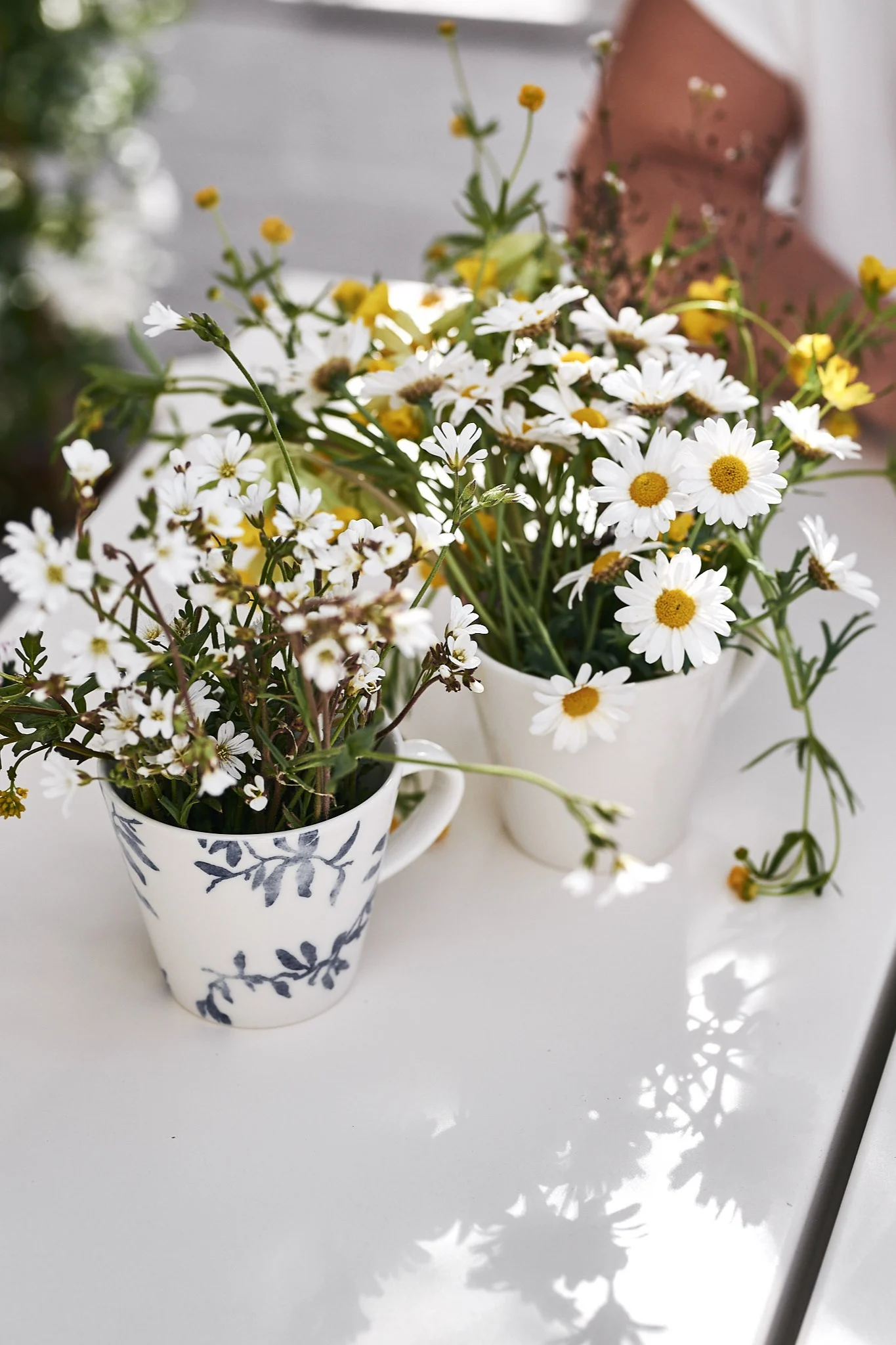 Sommarblommorna huserar i vit och blåvit kaffekopp från Nordic Nest – redo att plockas till midsommarkransen.