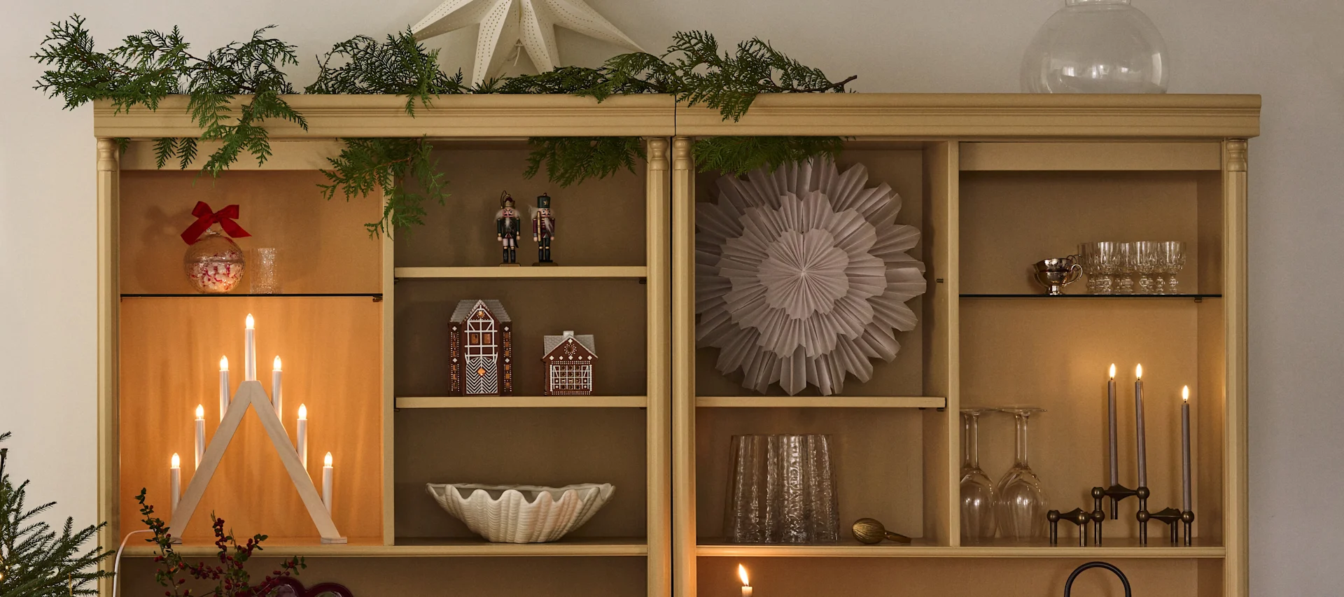 Juldekorerad bokhylla med julstjärnor och ljusstake som är perfekt för att komma i stämning till första advent. 