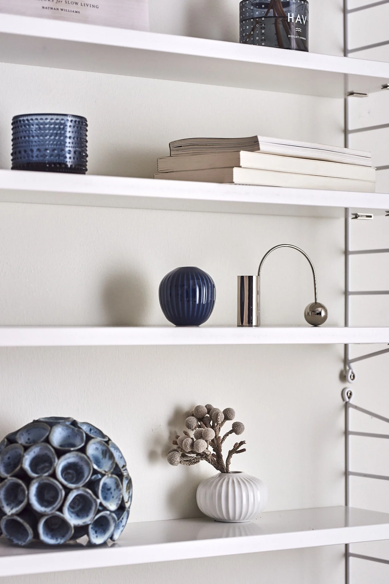 String Pocket-hylla i vitt med blå inredningsdetaljer visar hur man kan styla en hylla i klassisk look.